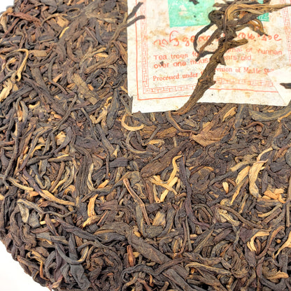 Close-up of a round tea cake with a label in the background
