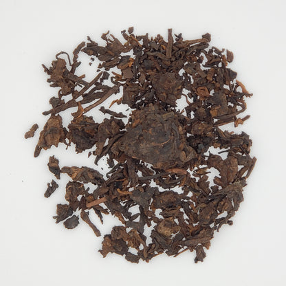 Close up of pu-erh tea leaves on a white background