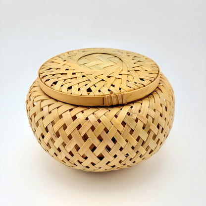 Woven bamboo basket with lid on a white background