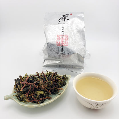 Tea packaging, a cup of tea, and a leaf-shaped dish with tea leaves on a white background