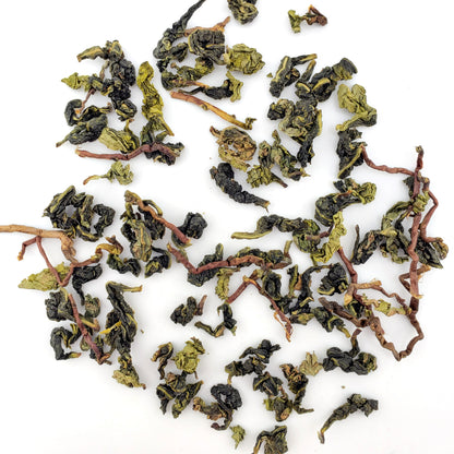 Dried green tea leaves on a white background
