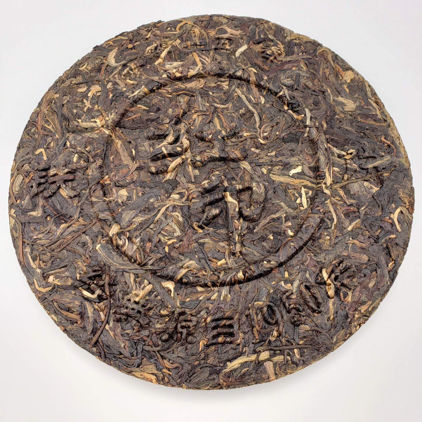 Round dark brown tea cake with text on a white background
