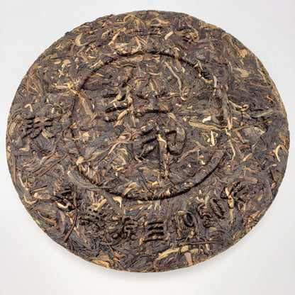Round dark brown tea cake with text on a white background