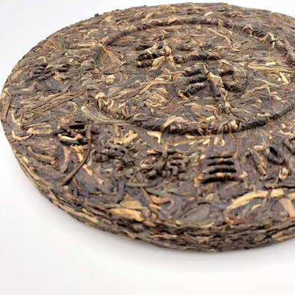 Close up of a tea cake pressed using a mold, leaving Chinese characters raised on the surface