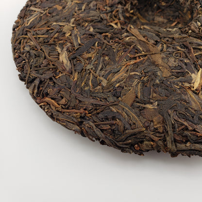 Close-up of pressed pu-erh tea cake on a white background