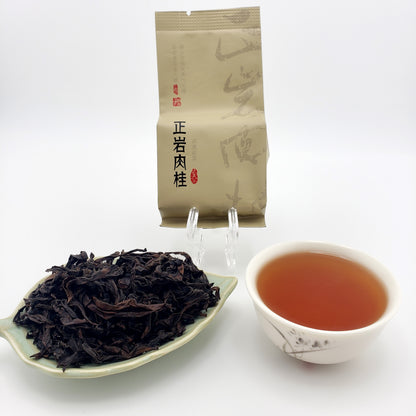 Tea packaging, cup of tea, and tea leaves on a white background