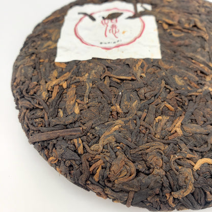 Close-up of a pressed tea cake with a white label on a white background