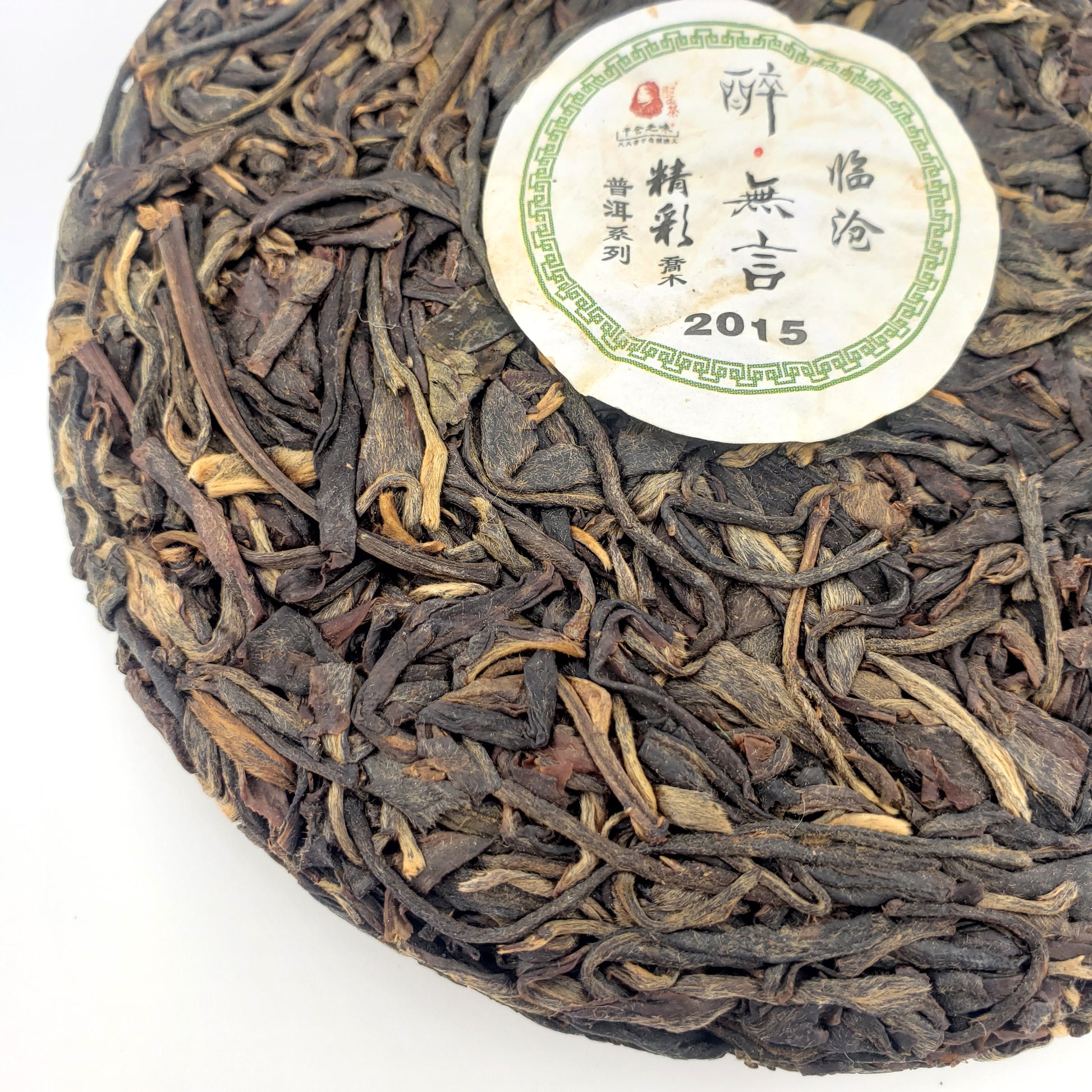 Round cake of compressed tea leaves with a label on a white background