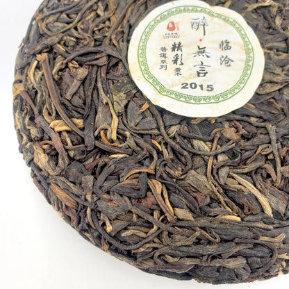 Round cake of compressed tea leaves with a label on a white background