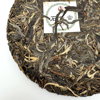 Round cake of pu-erh tea leaves with a nei fei label on a white background