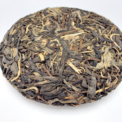 Close-up of a tea cake of dry tea leaves on a white background