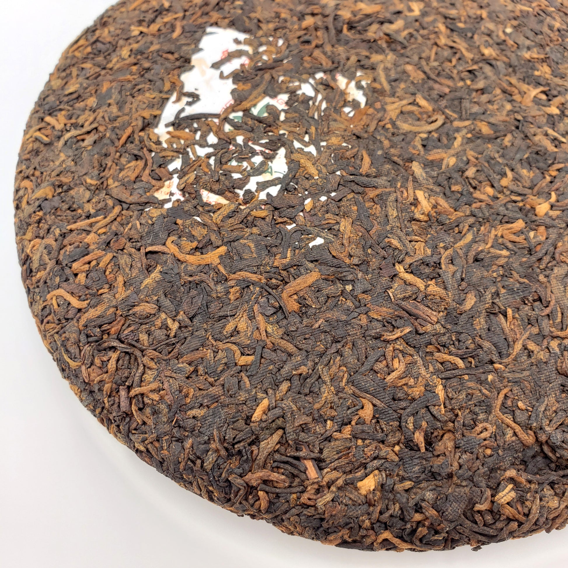 Close-up of a tea cake with visible tea leaves on a white background