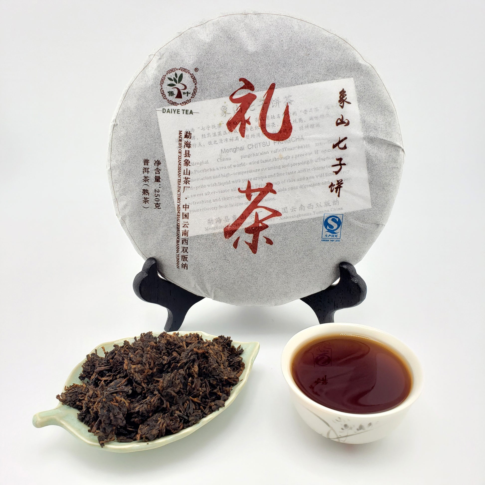 Tea cake with text, a cup of tea, and tea leaves on a white background