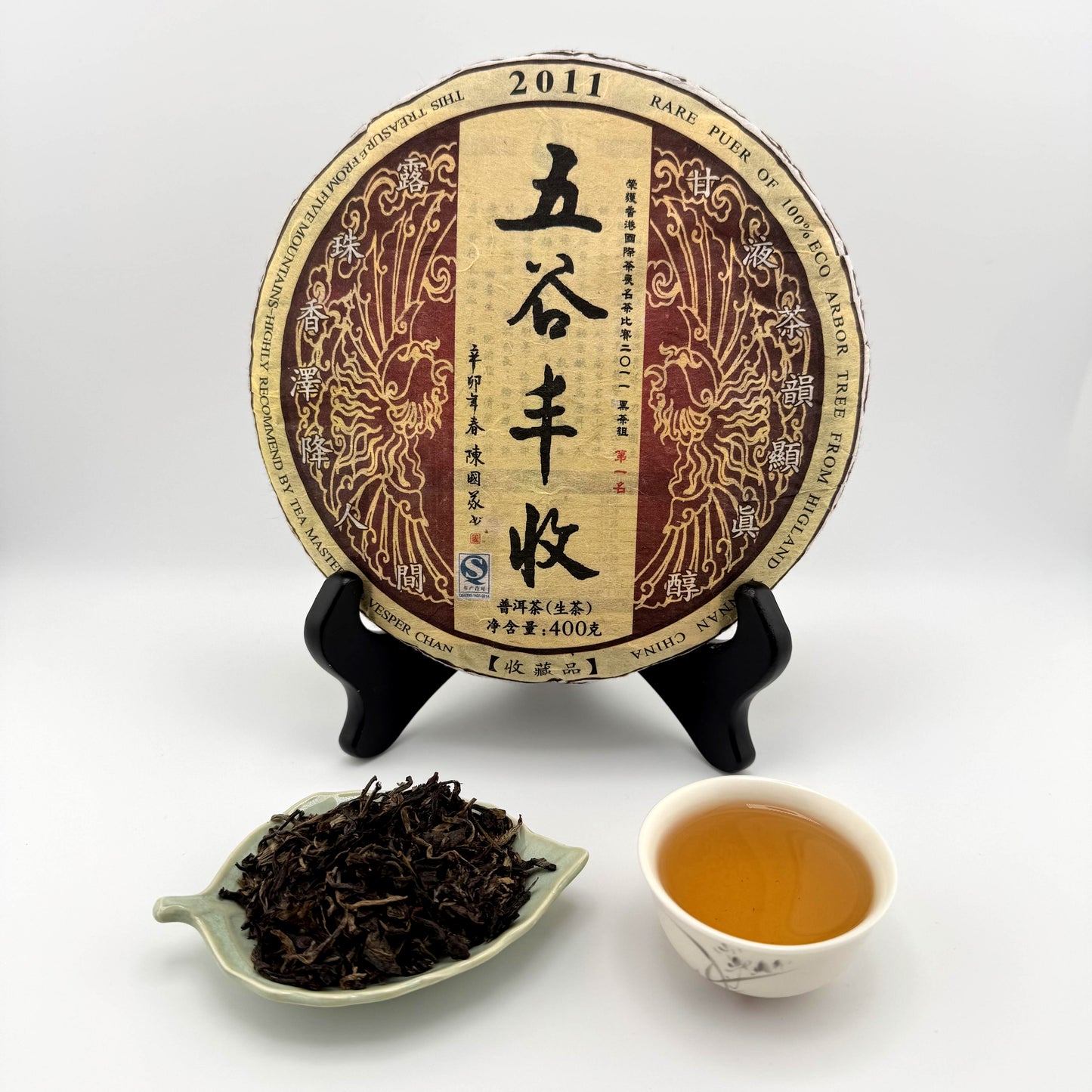 Tea cake with packaging, tea leaves, and a cup of tea on a white background
