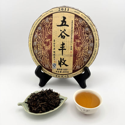 Tea cake with packaging, tea leaves, and a cup of tea on a white background