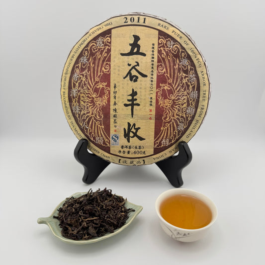 Tea cake with packaging, tea leaves, and a cup of tea on a white background