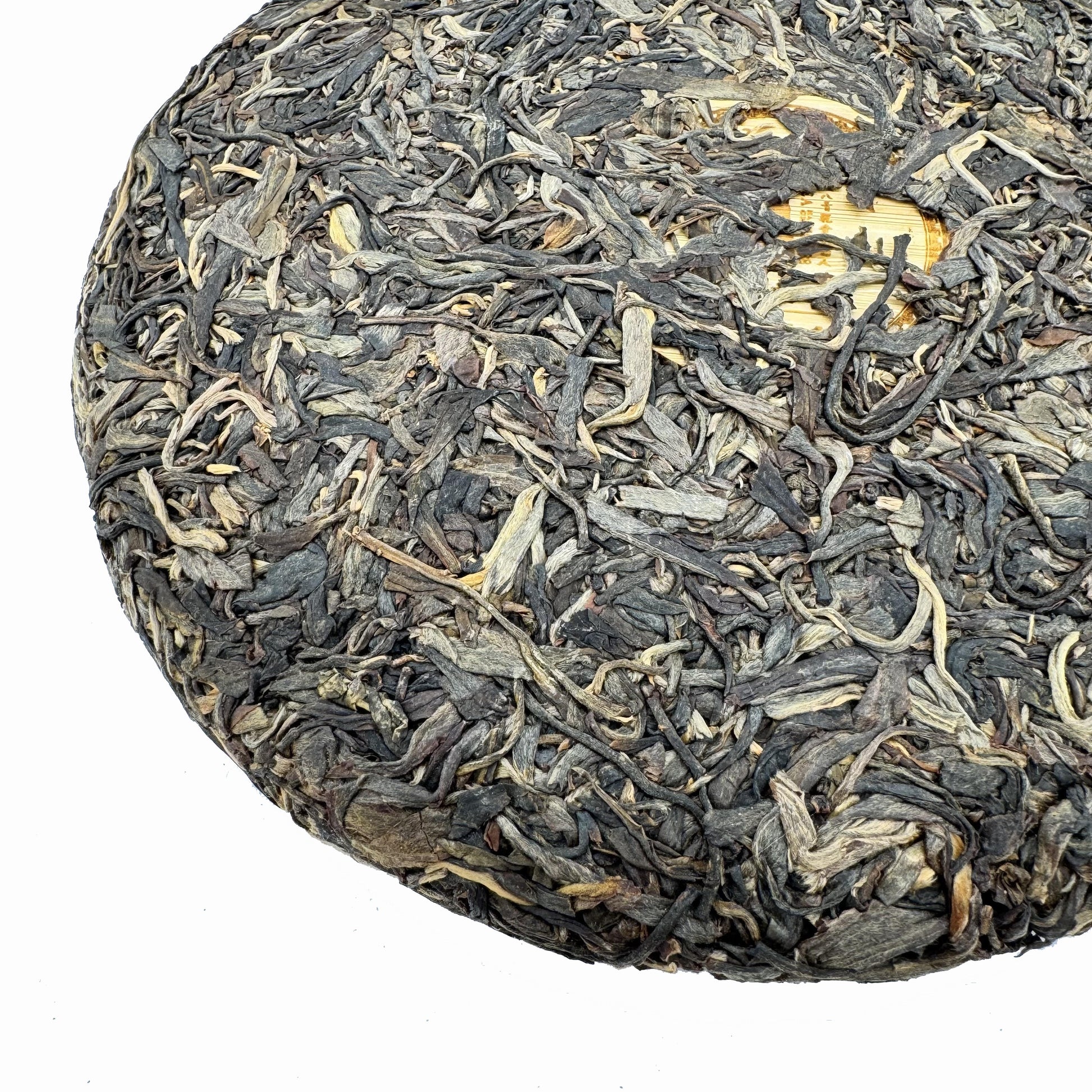 Round cake of compressed tea leaves on a light blue background