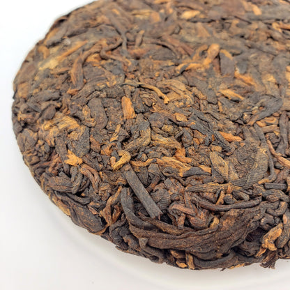 Close-up of a compressed tea ball with intricate texture on a white background