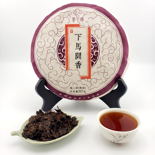 Puer tea cake with a cup of tea and tea leaves on a white background
