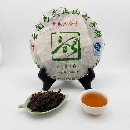 Tea cake with a tea leaf scoop and cup of tea on a white background