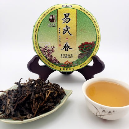 Tea packaging, brewed tea in a cup, and loose tea leaves on a white background