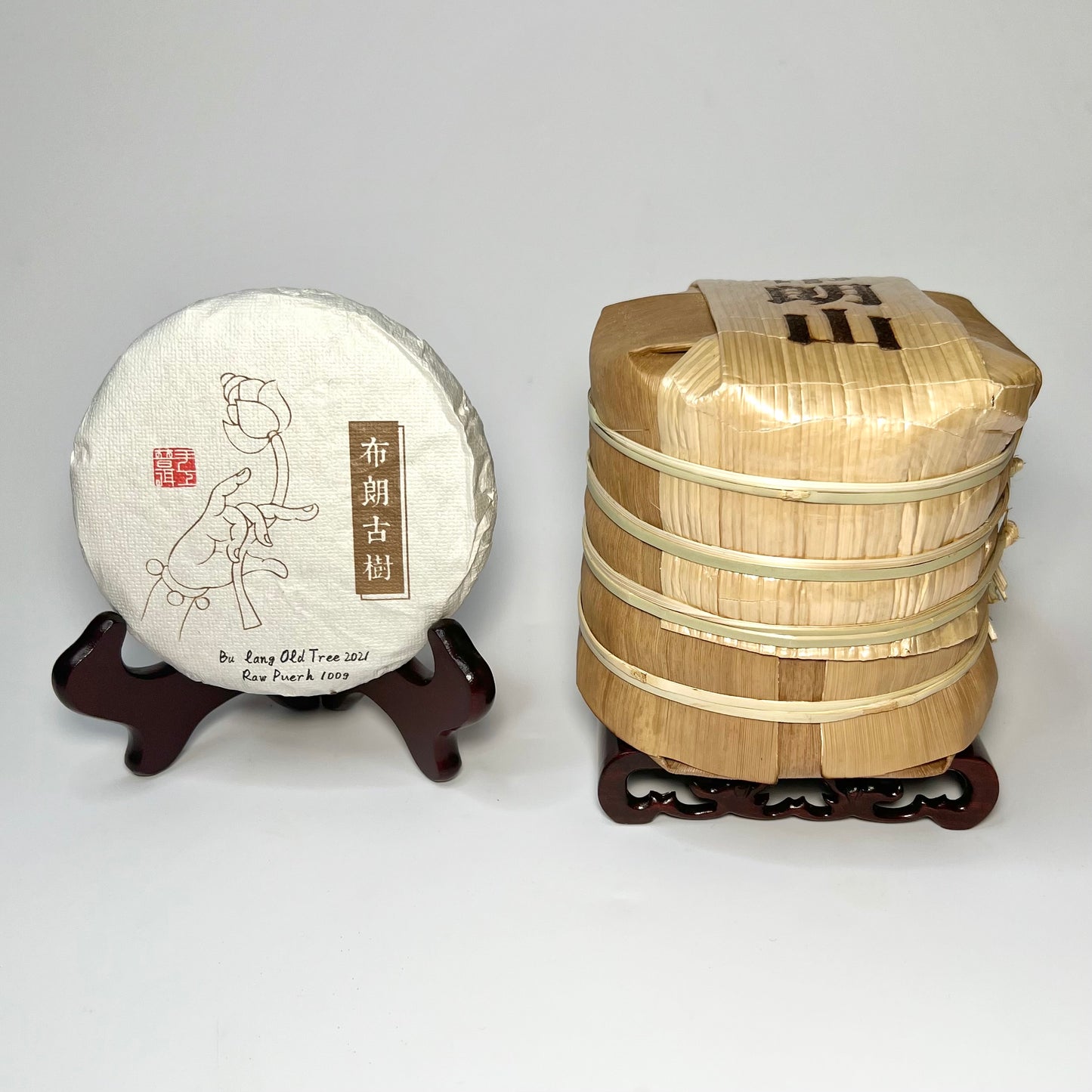 Individual tea cake next to a tong of 5 tea cakes packed in bamboo leaves
