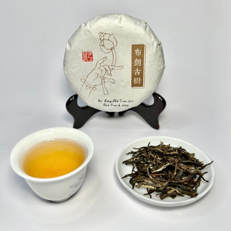Tea packaging, brewed tea in a cup, and tea leaves on a white background