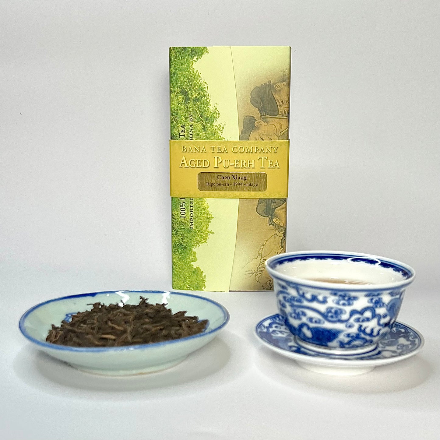 Tea packaging with a bowl of tea leaves and a teacup on a white background