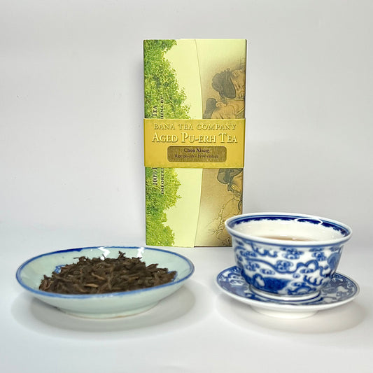 Tea packaging with a bowl of tea leaves and a teacup on a white background