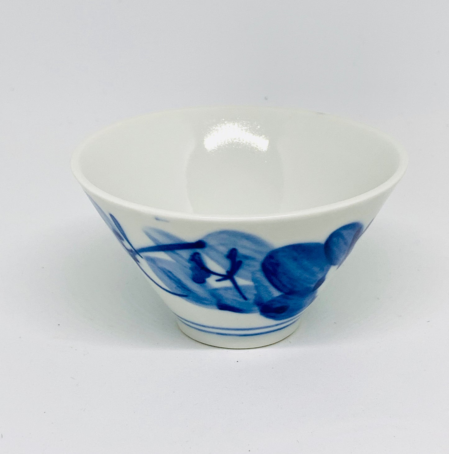 White ceramic bowl with blue floral design on a white background