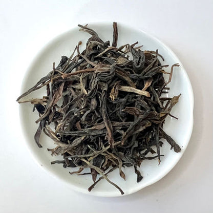 Dry black tea leaves on a white plate