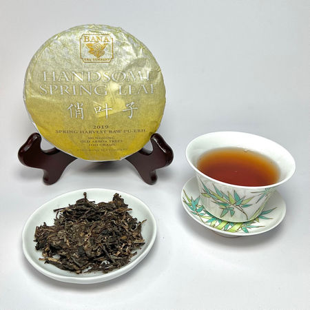 Tea cake, loose tea leaves, and a cup of tea on a white background