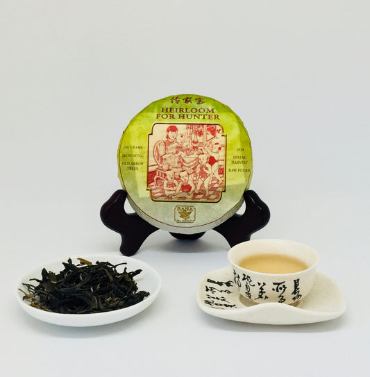 Tea packaging, tea leaves, cup with tea, and saucer on a white background