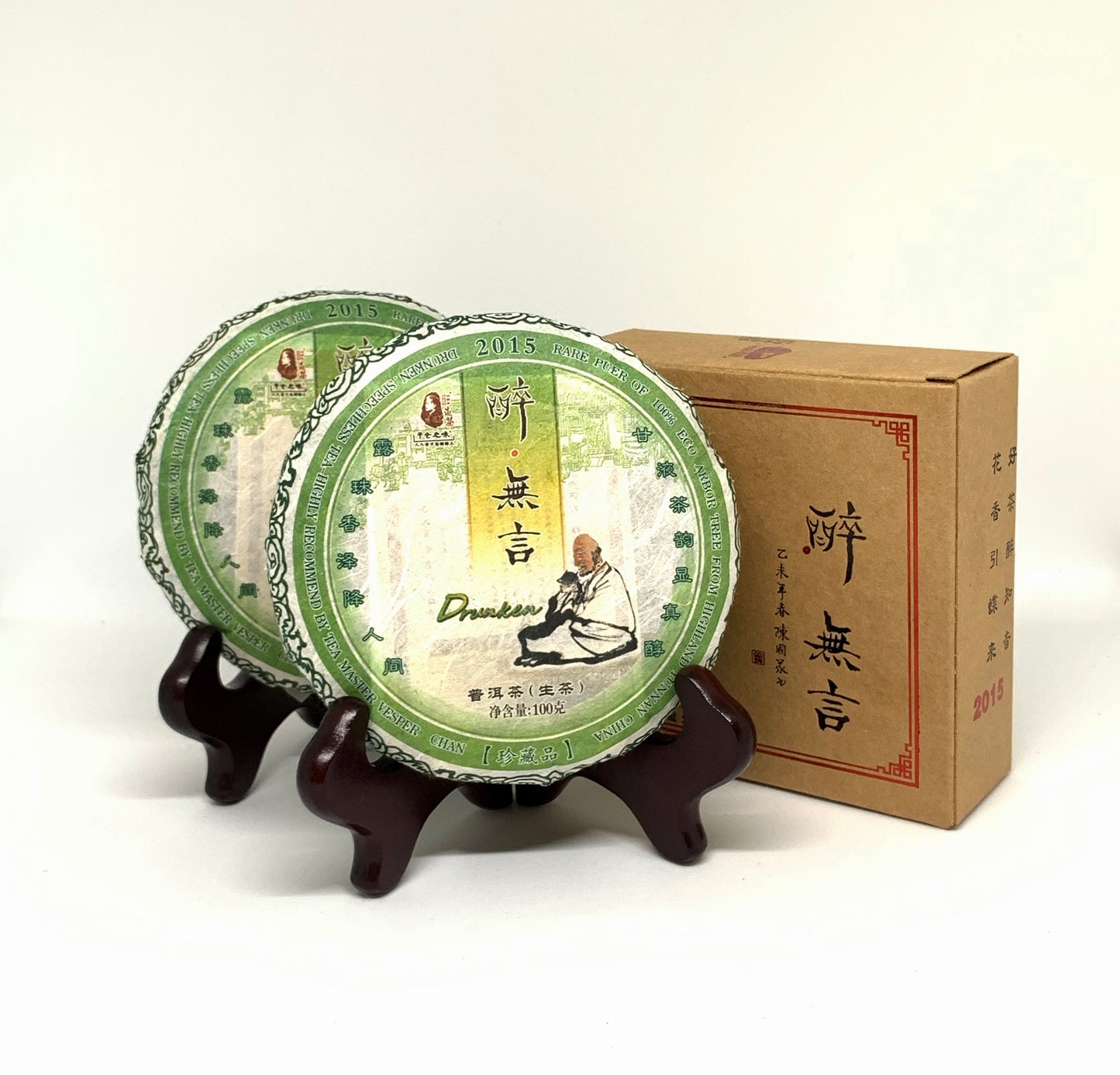 Two green tea cakes on a wooden stand with a cardboard box in the background.