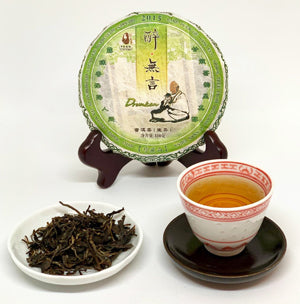 Tea packaging, cup of tea, and dry tea leaves on a white background