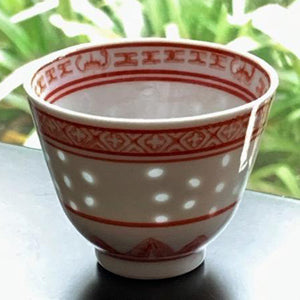 Decorative bowl with red patterns on a gray surface