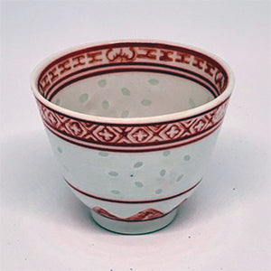 Ceramic cup with red decorative patterns on a white background