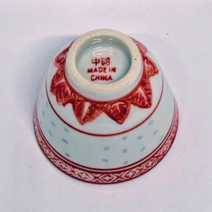Small ceramic bowl with red decorative rim and 'Made in China' text on a white background